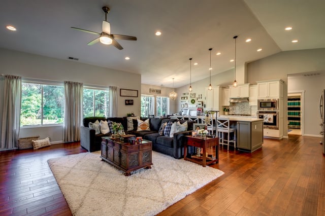 Open living room and kitchen with hardwood floors in custom home